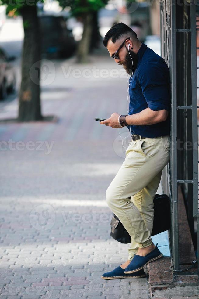 bearded man standing and listening to music photo