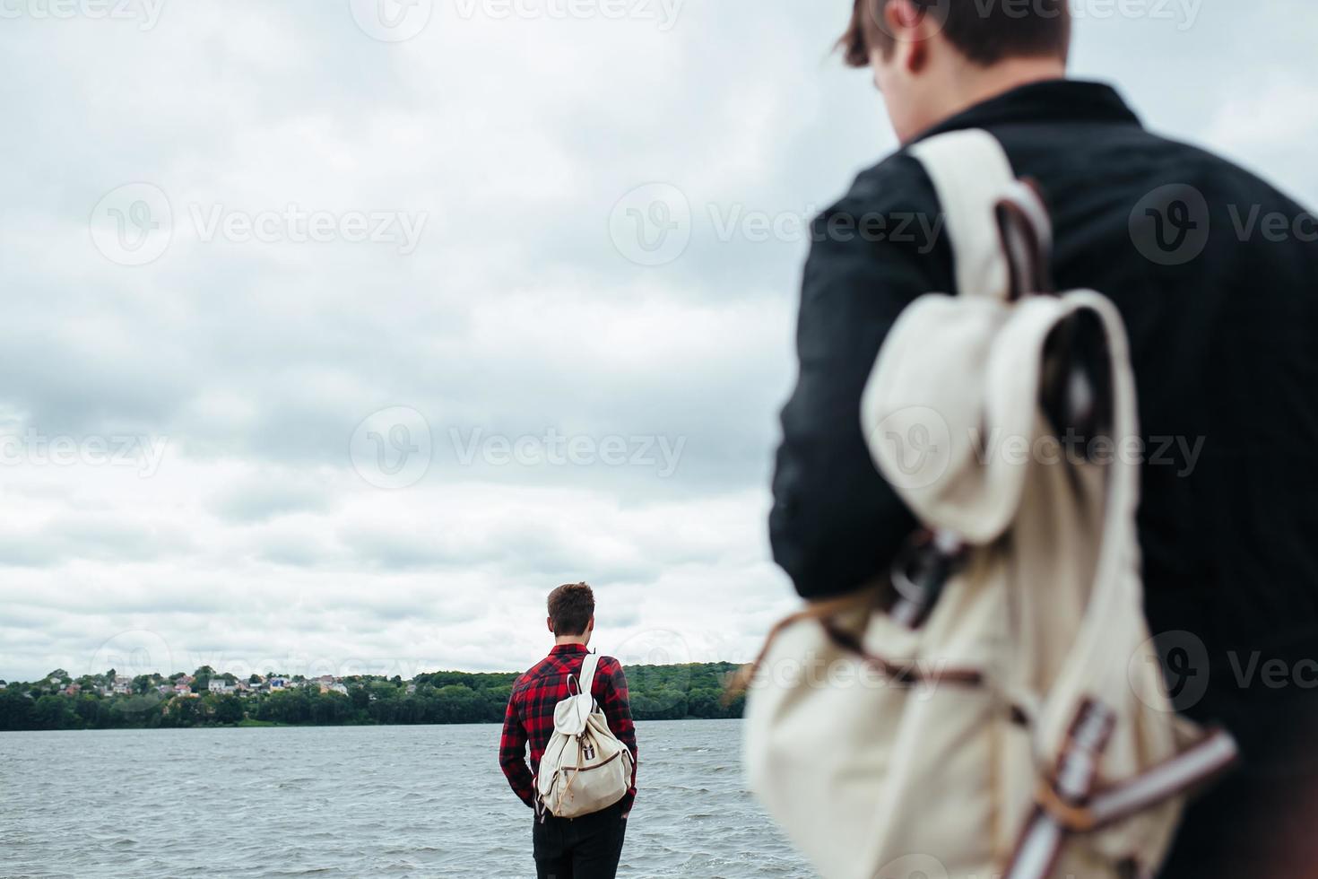 two young guys standing on a pier photo