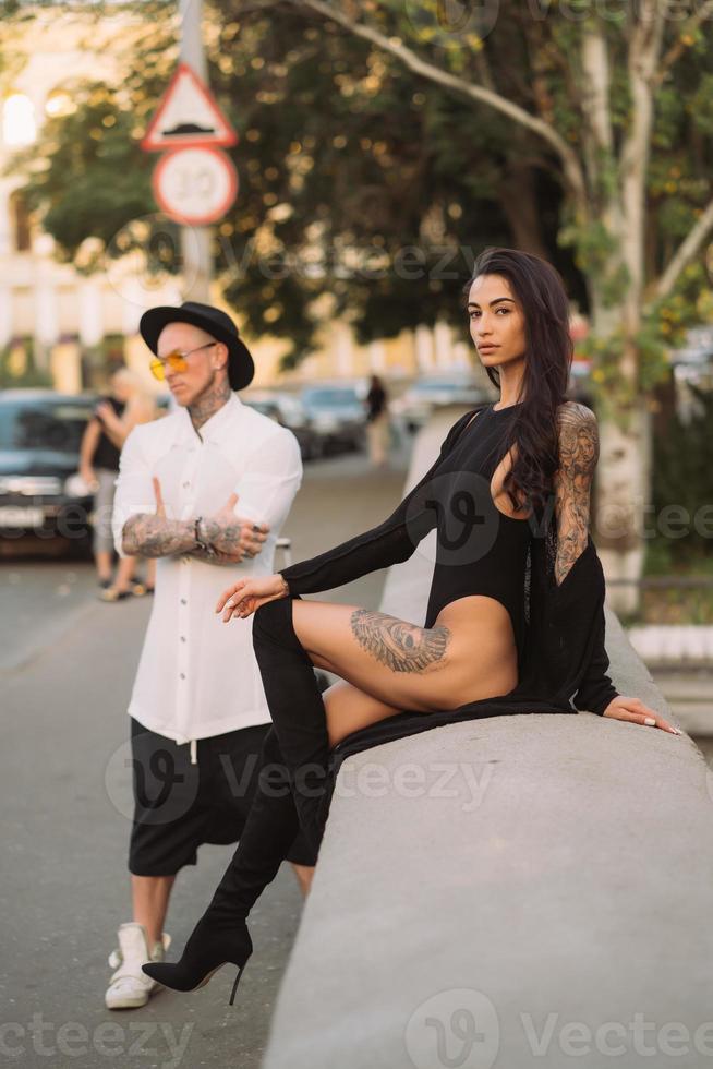 A young, sexy couple of lovers pose for a camera on the streets photo