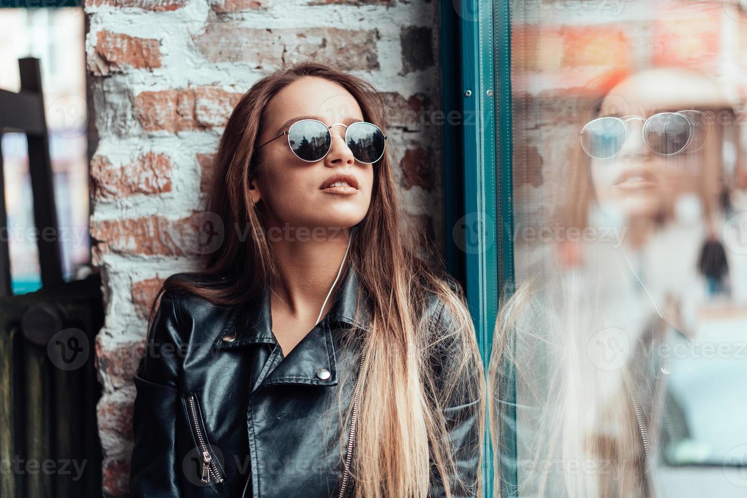 Beautiful girl in sunglasses posing on camera photo