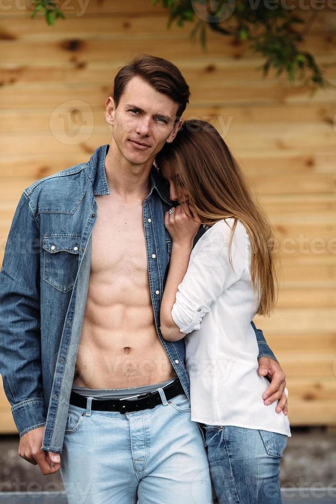 couple posing on a background of the wooden wall photo