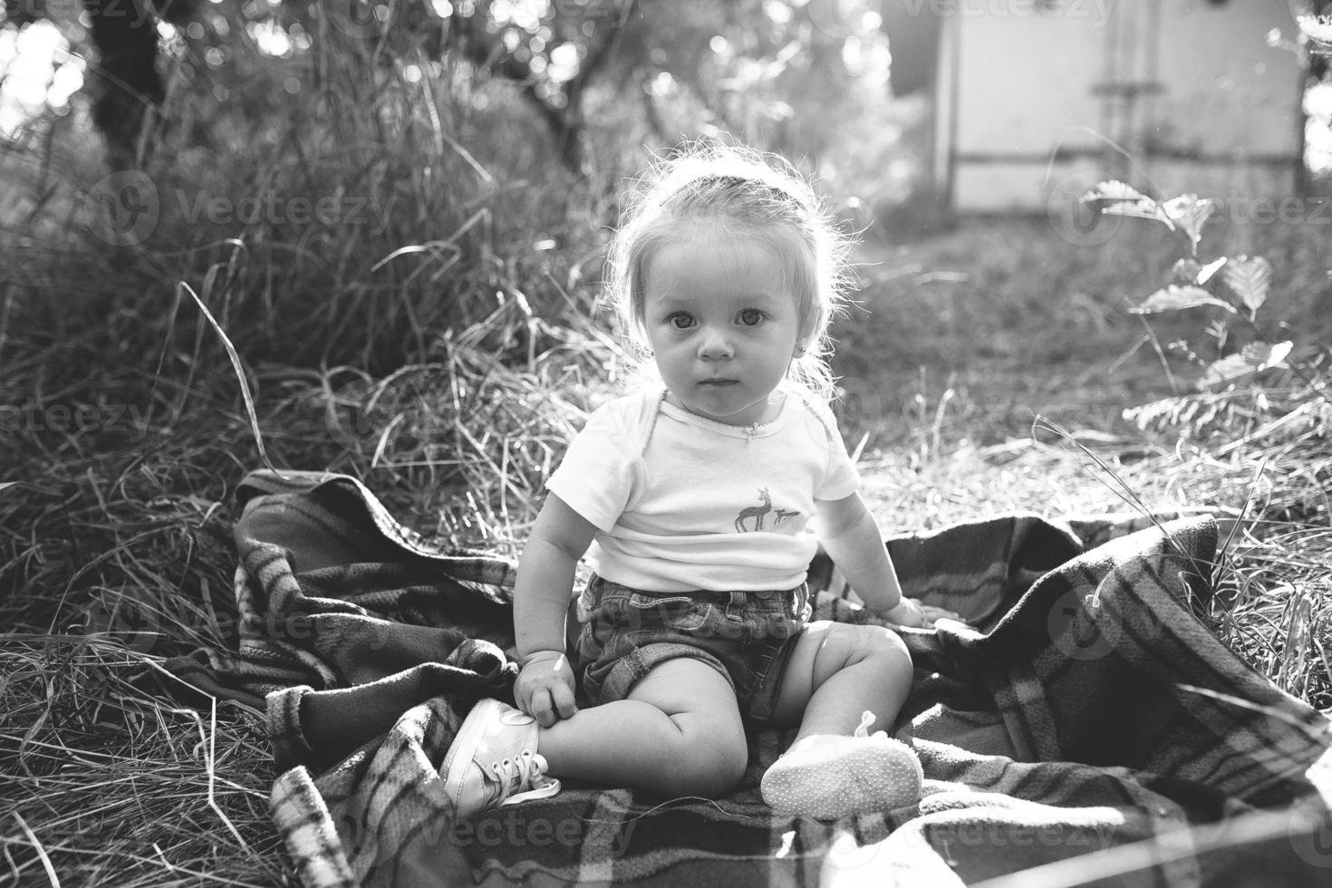 little girl sitting on the lawn photo