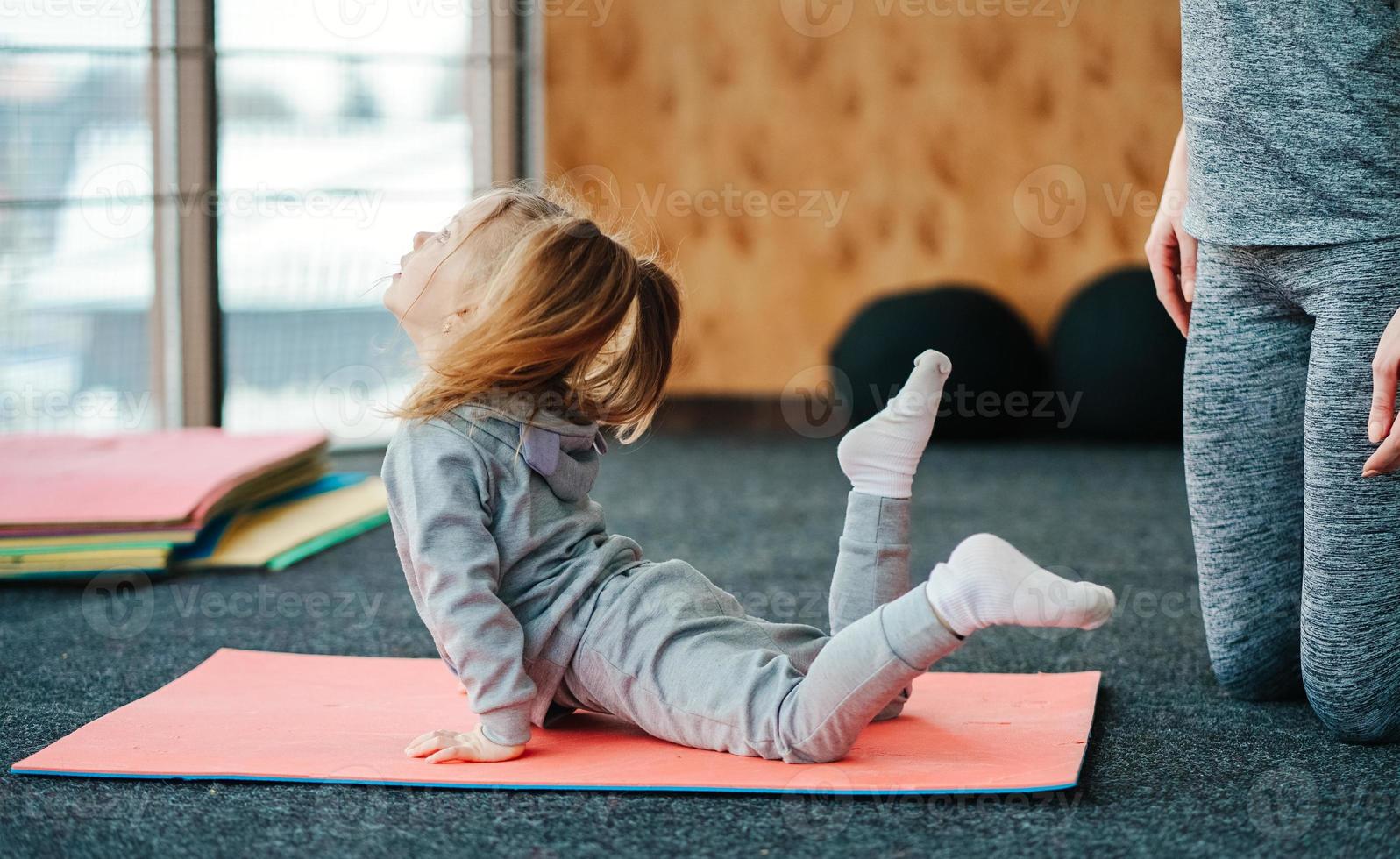 A little girl repeats exercises for her mother photo