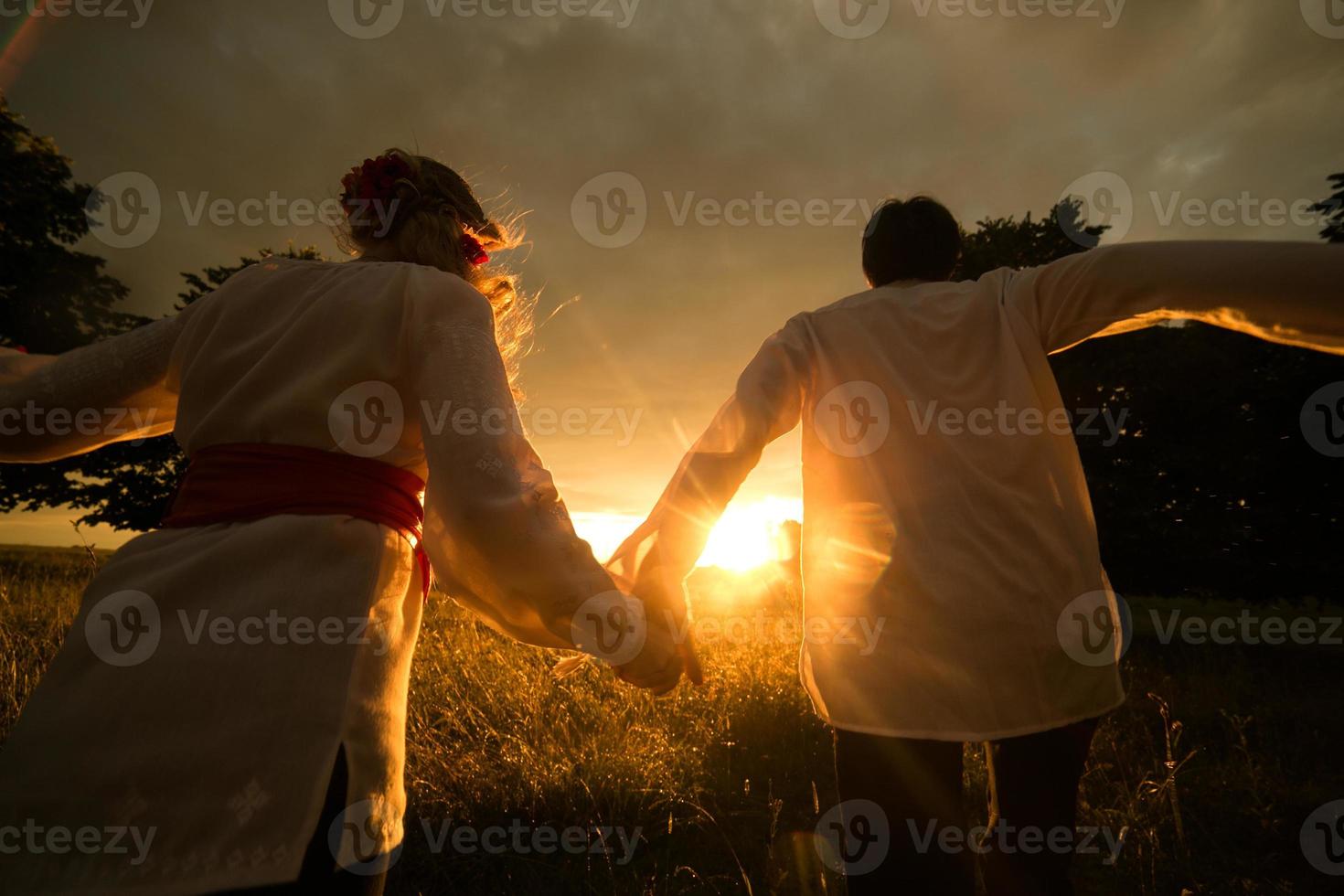 Couple running to the sunset photo