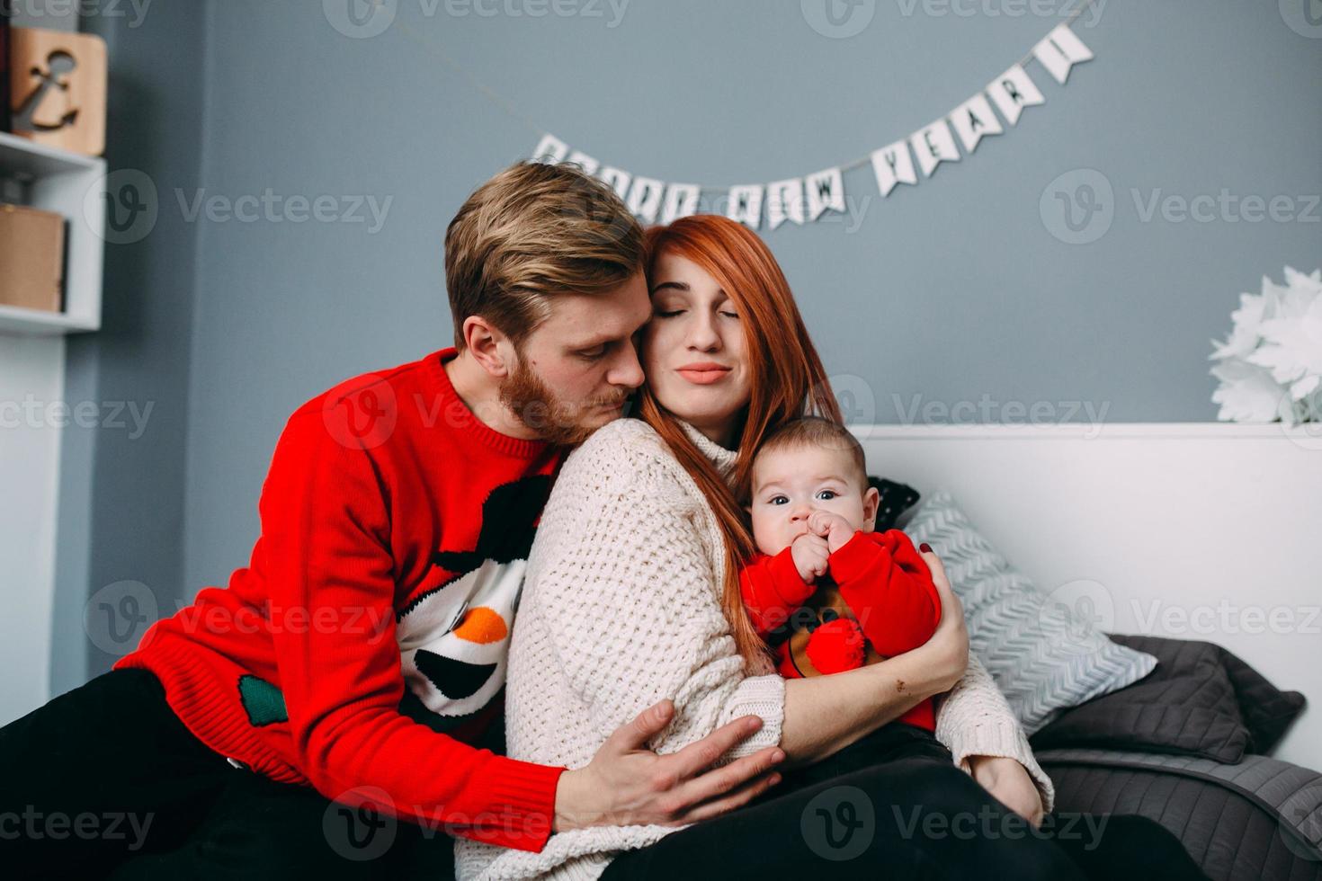 Happy family with newborn baby on the bed photo