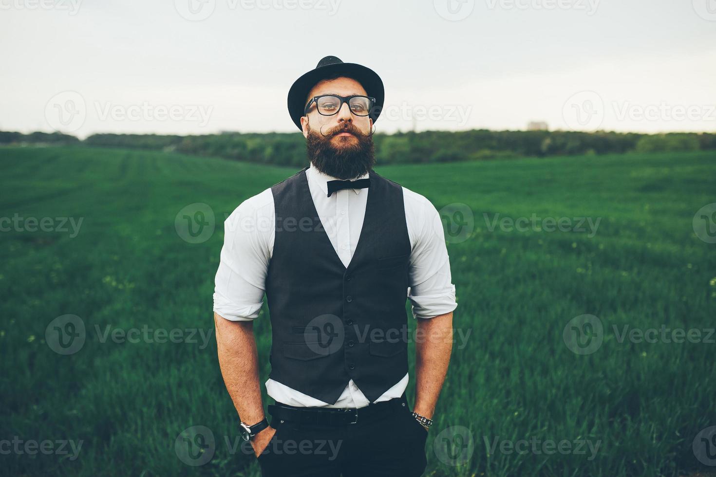 A man with a beard and sunglasses walking on the field photo