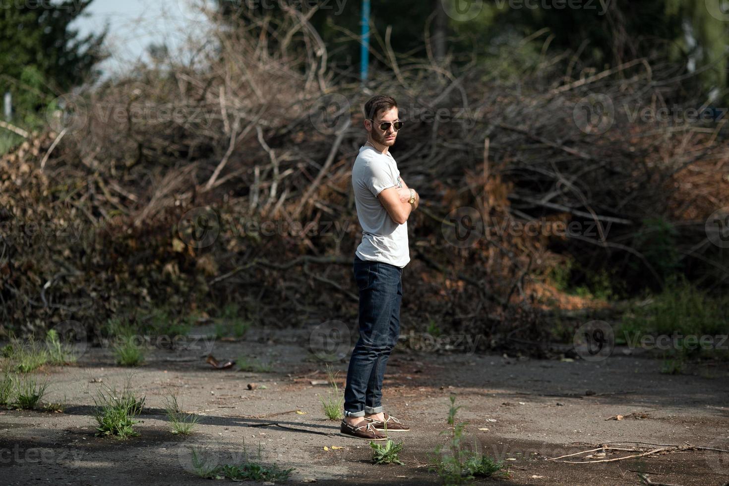 The man in the authentic boots and selvedge jeans  on a the background of branches photo