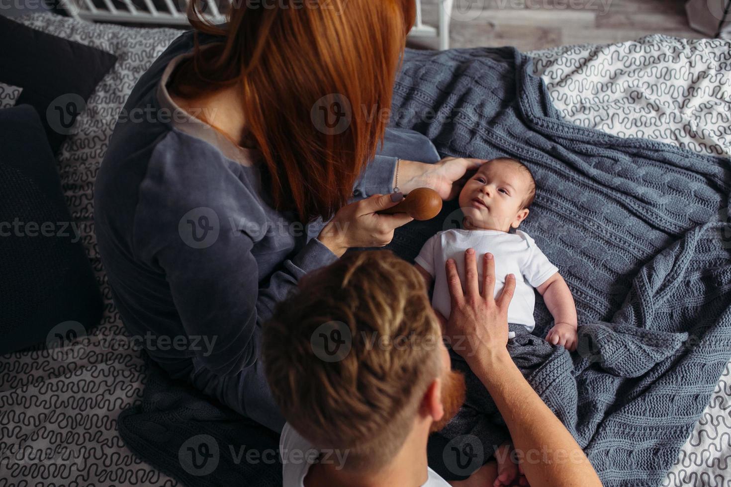 padres jóvenes prestando atención a su bebé. foto