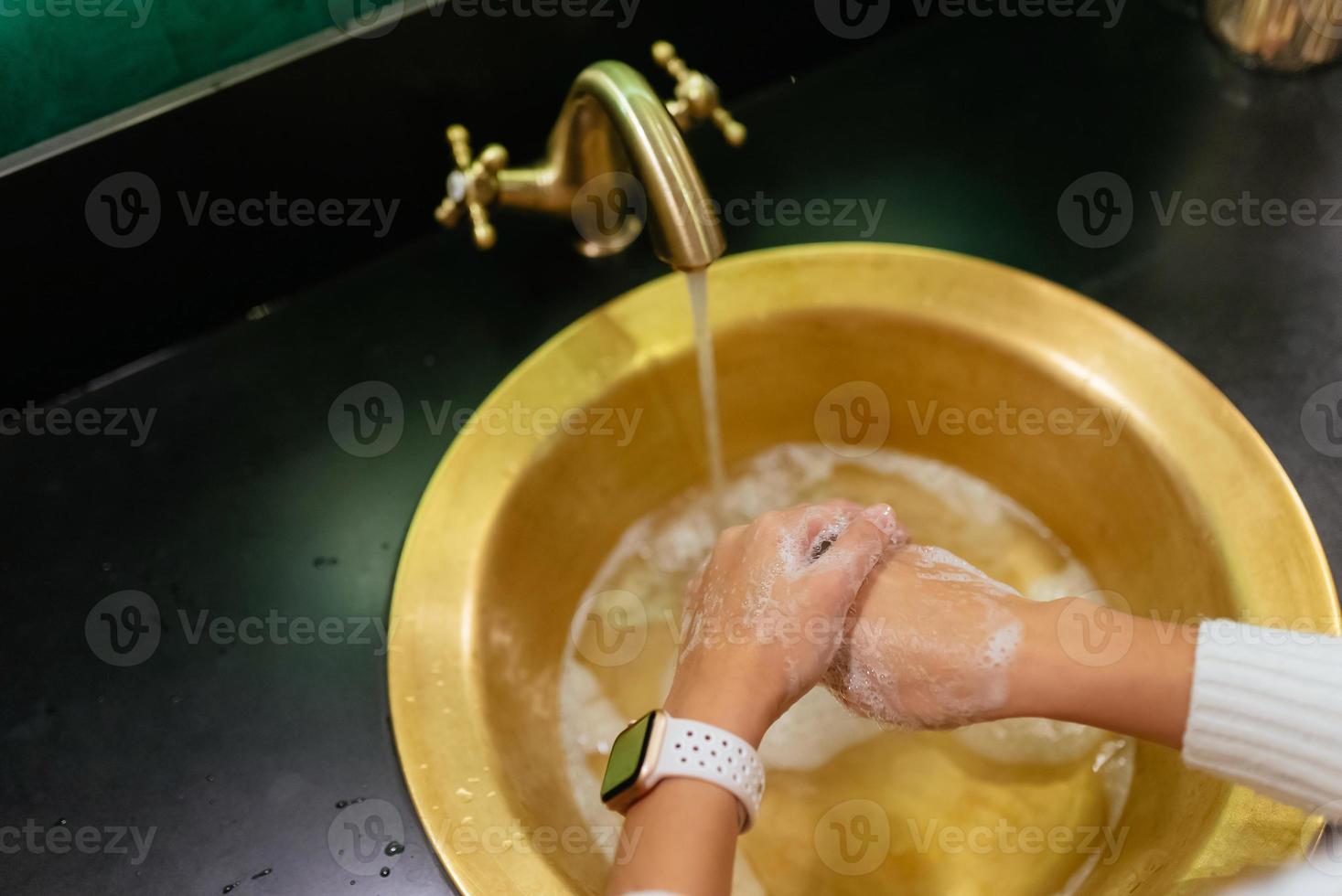 Close up photo of woman washes her hands with soap and water.