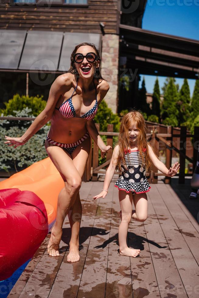 Mom and daughter near the pool, outdoor photo