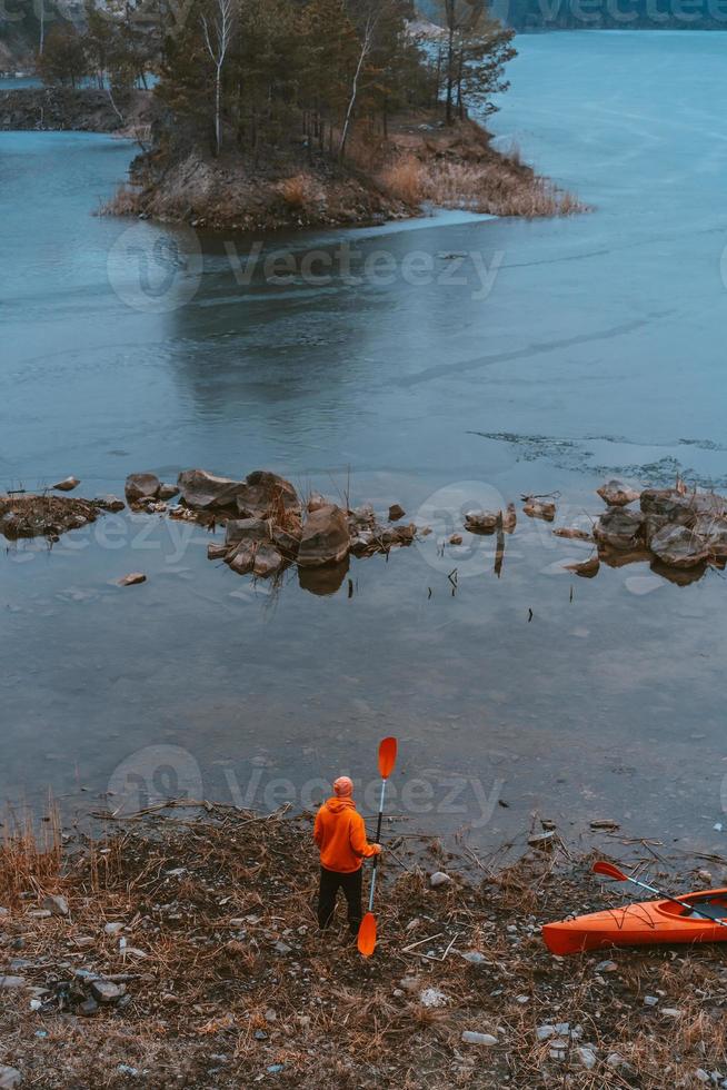 The guy is standing at the frozen lake photo