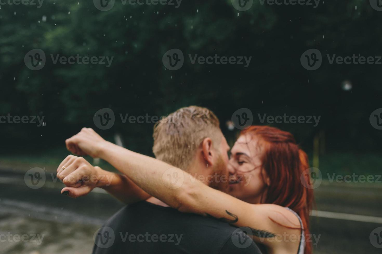 beautiful couple kissing  in the rain photo