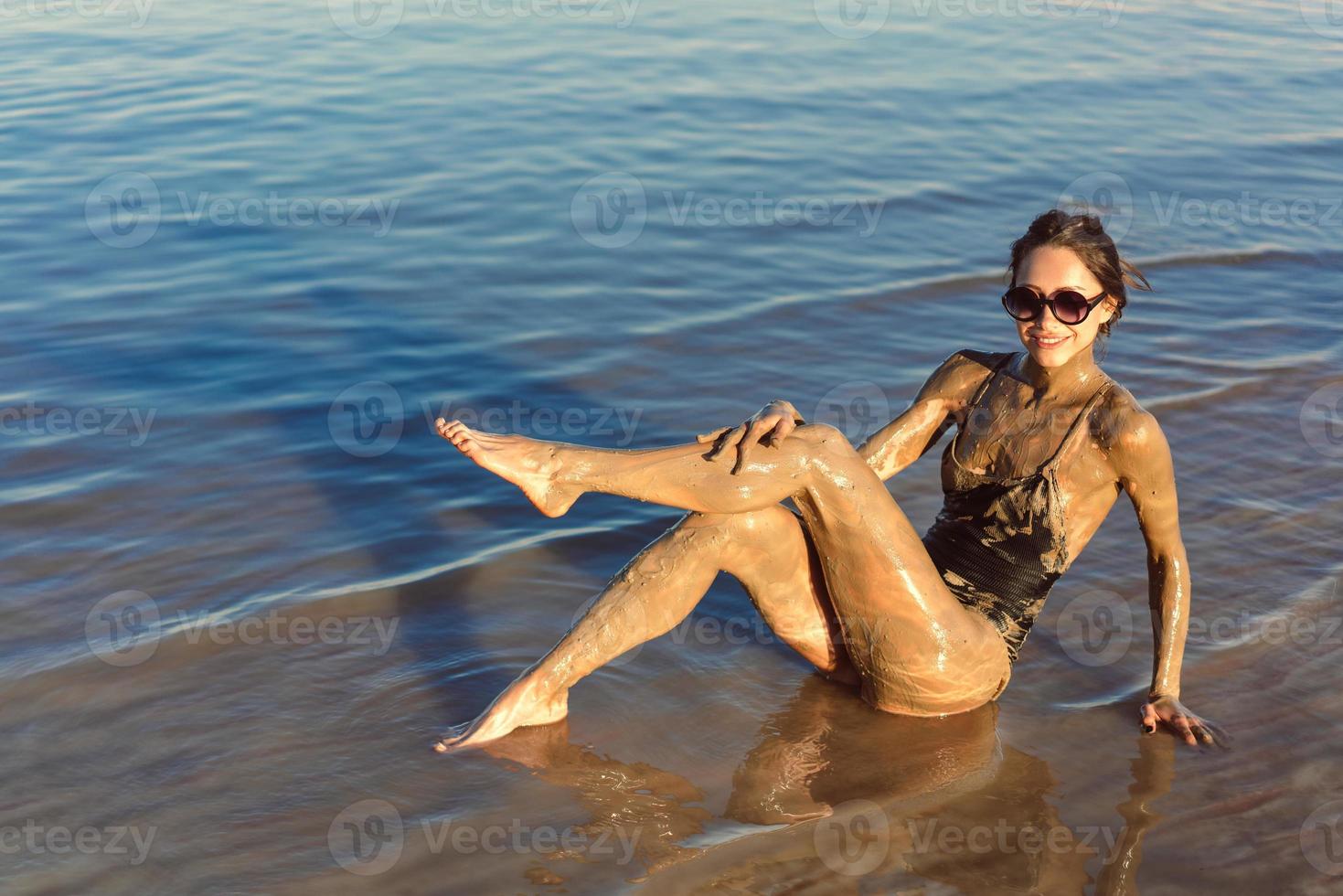 una joven disfrutando del barro mineral natural foto