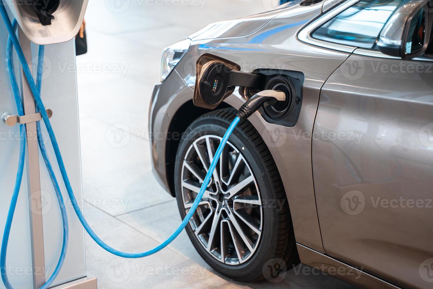 Power supply plugged into an electric car being charged. photo