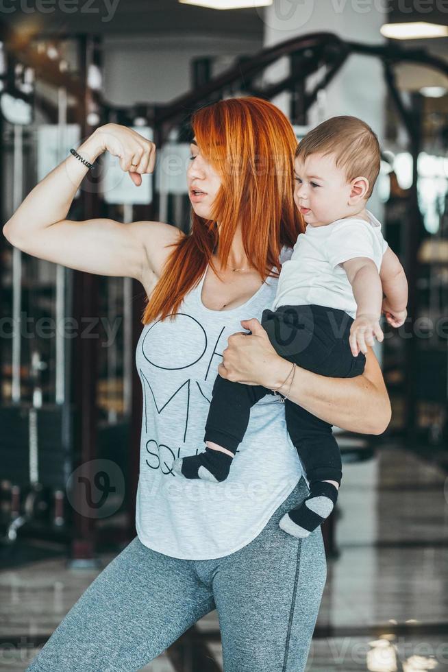 joven madre con su hijo pequeño en el gimnasio foto