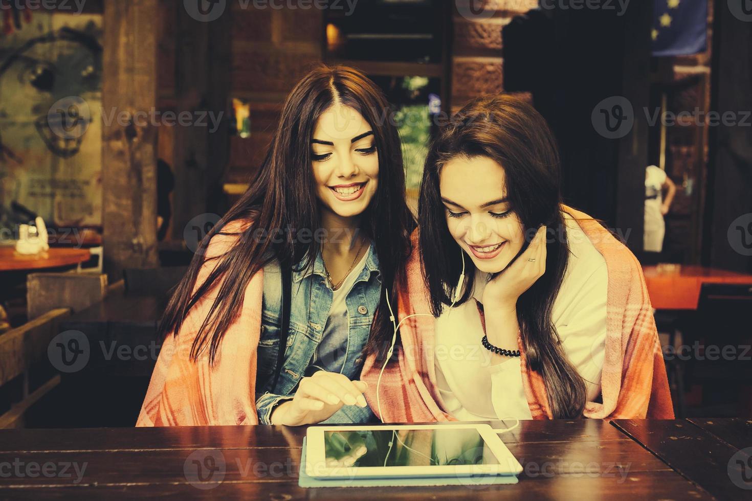 two close friends watching something on a tablet photo