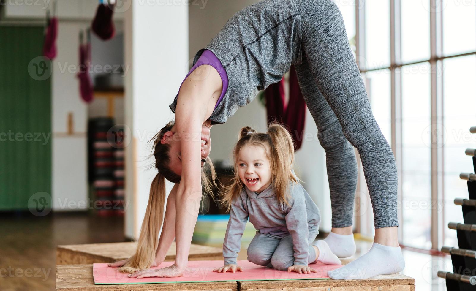 Mom and daughter together perform different exercises photo