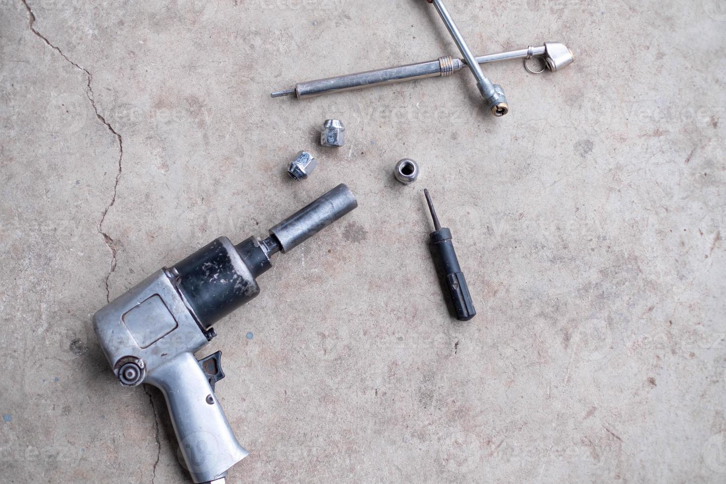 Auto repair tools on cement floor in car repair shop photo