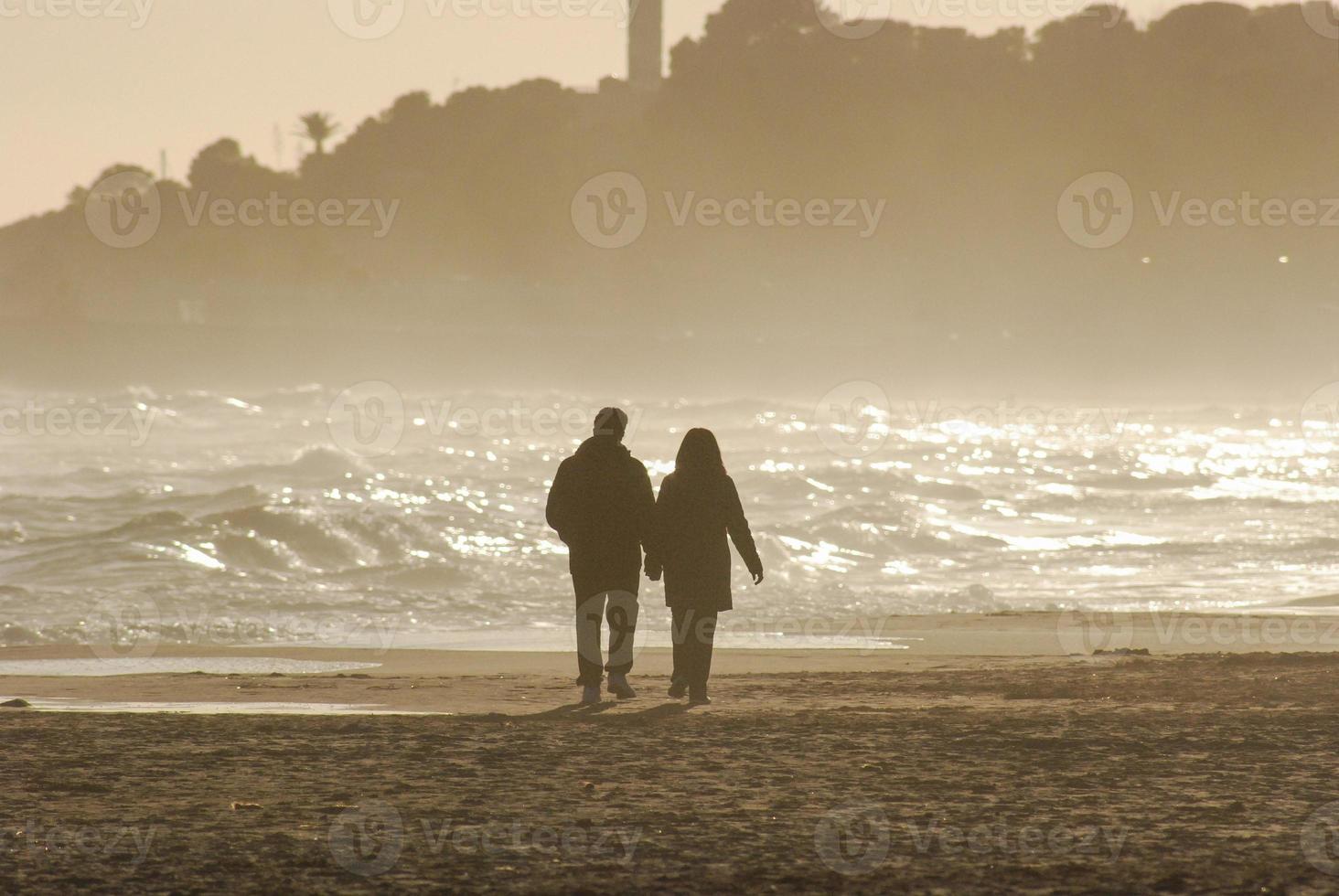 lovers walking on a beach photo