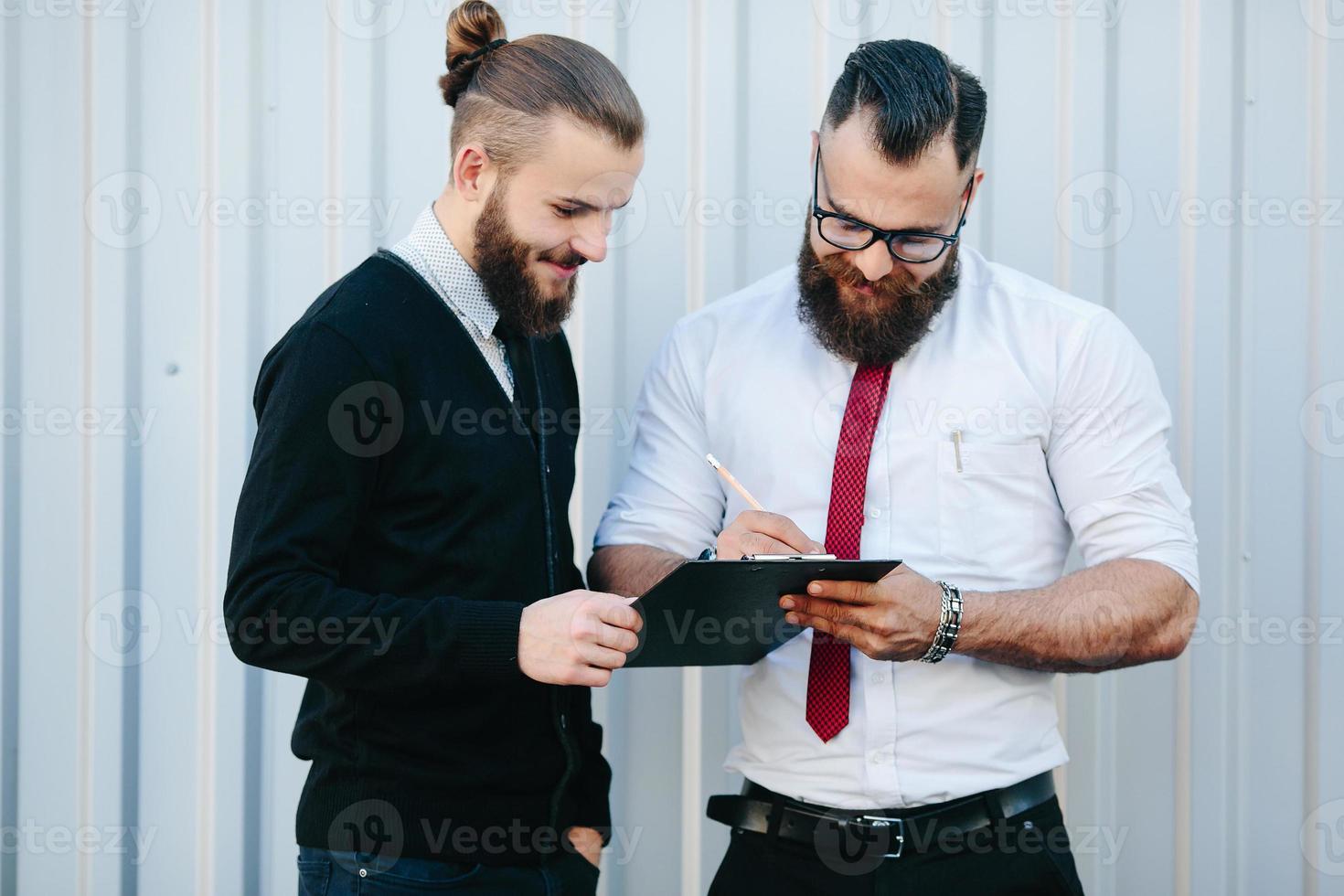 Two bearded businessman signing documents photo
