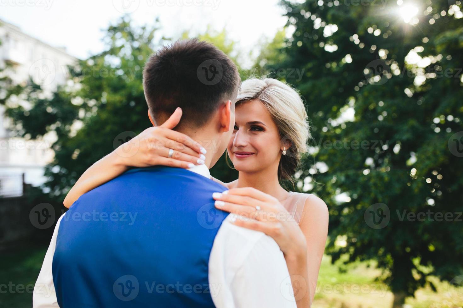 Beautiful wedding couple hugging in the park photo