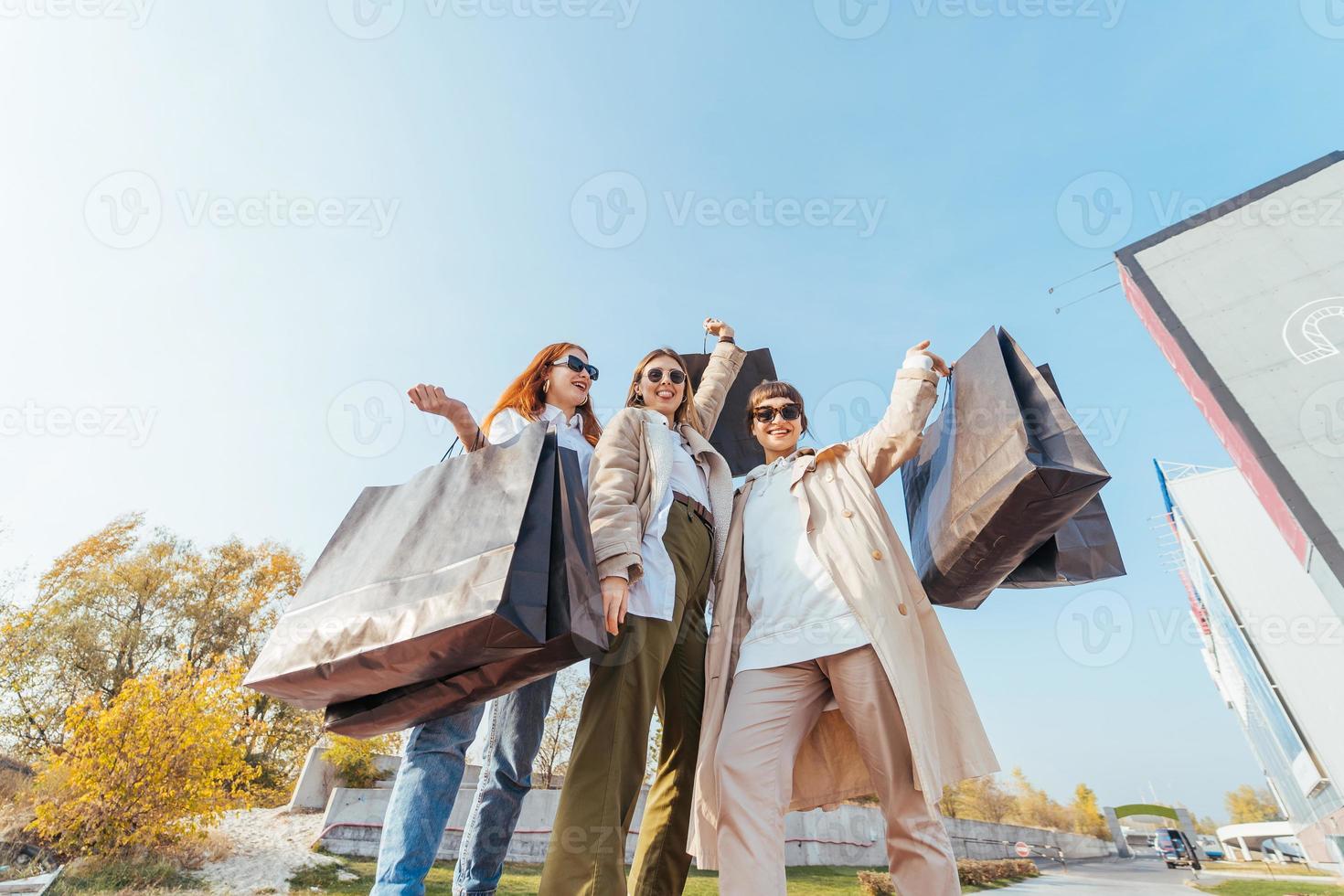 mujeres jóvenes con bolsas en las manos posando para la cámara foto