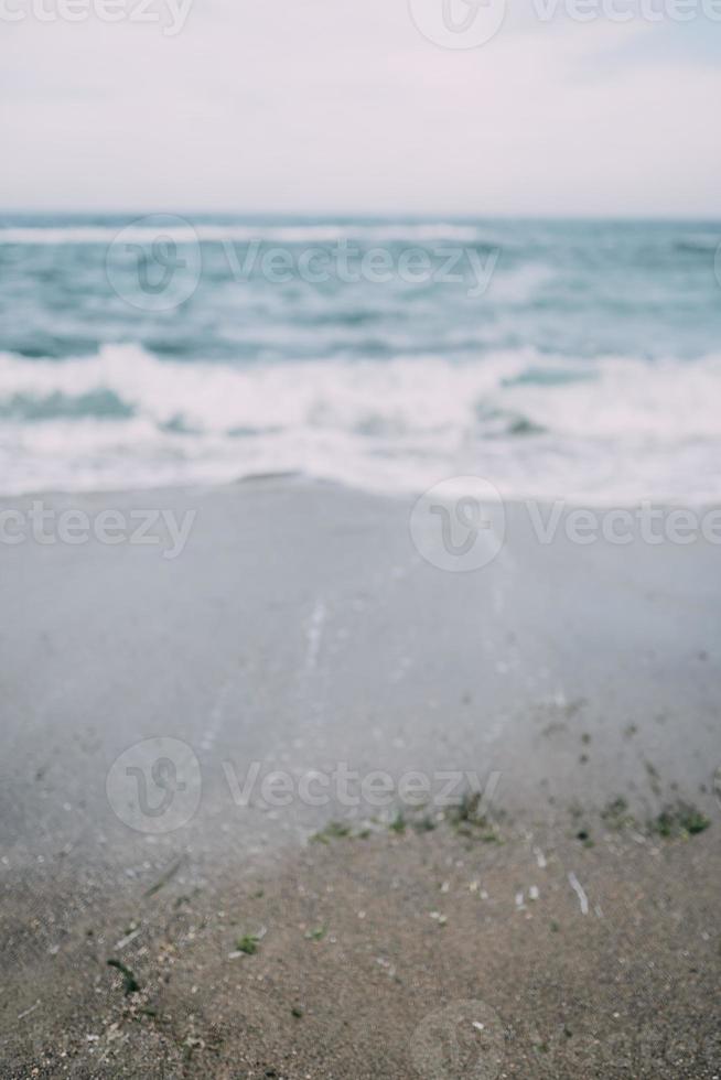 Sea with the waves crashing on to the beach creating sea spray. photo