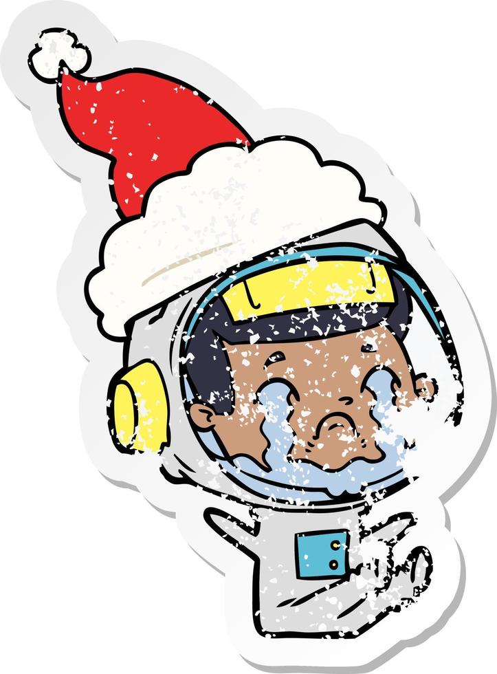 distressed sticker cartoon of a crying astronaut wearing santa hat vector