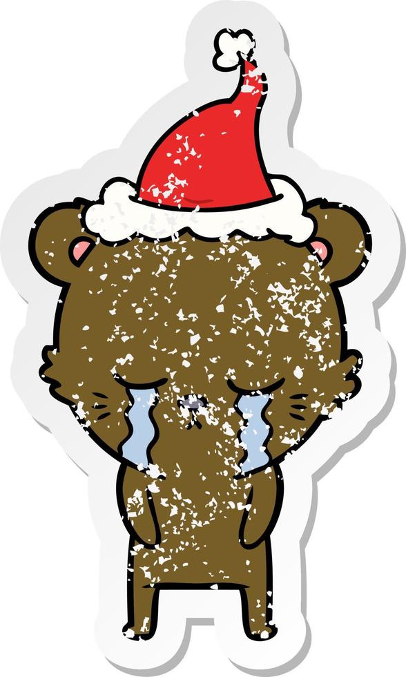 crying distressed sticker cartoon of a bear wearing santa hat vector