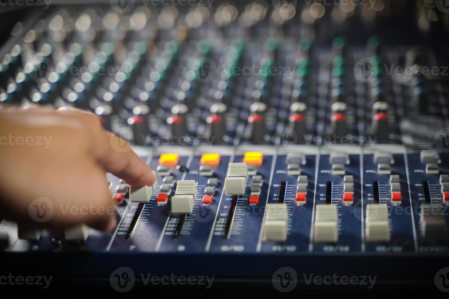 Men's hands are controlling the console of a large hi-fi system.with flair light photo