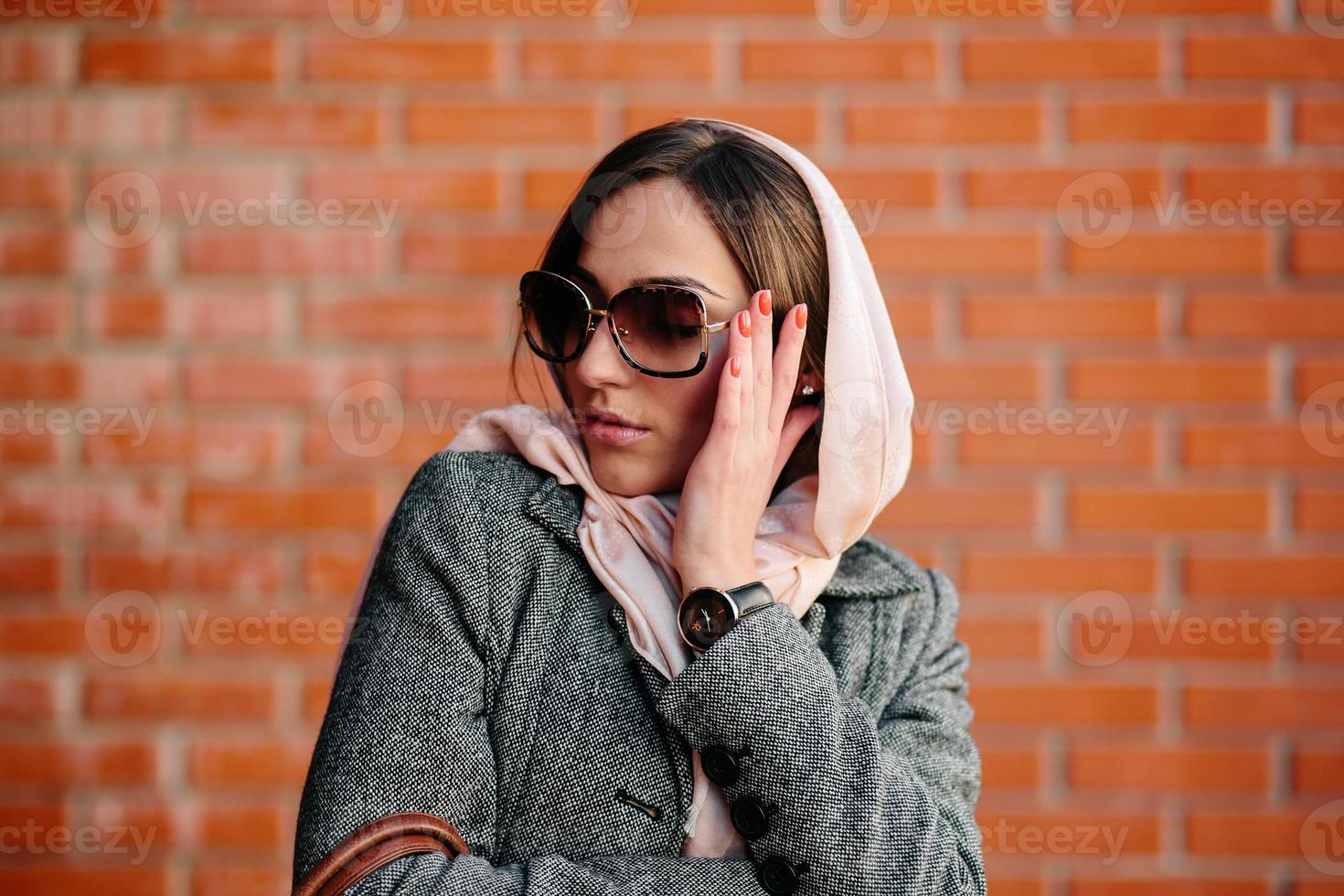 girl posing on a background of red brick wall photo