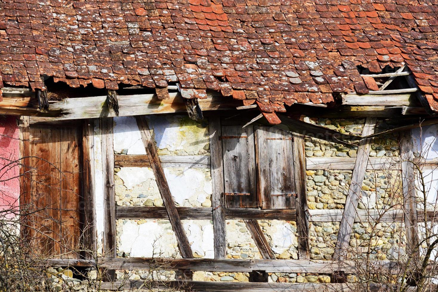 Detail and section of the facade of an old half-timbered house that is slowly falling apart and is no longer habitable photo