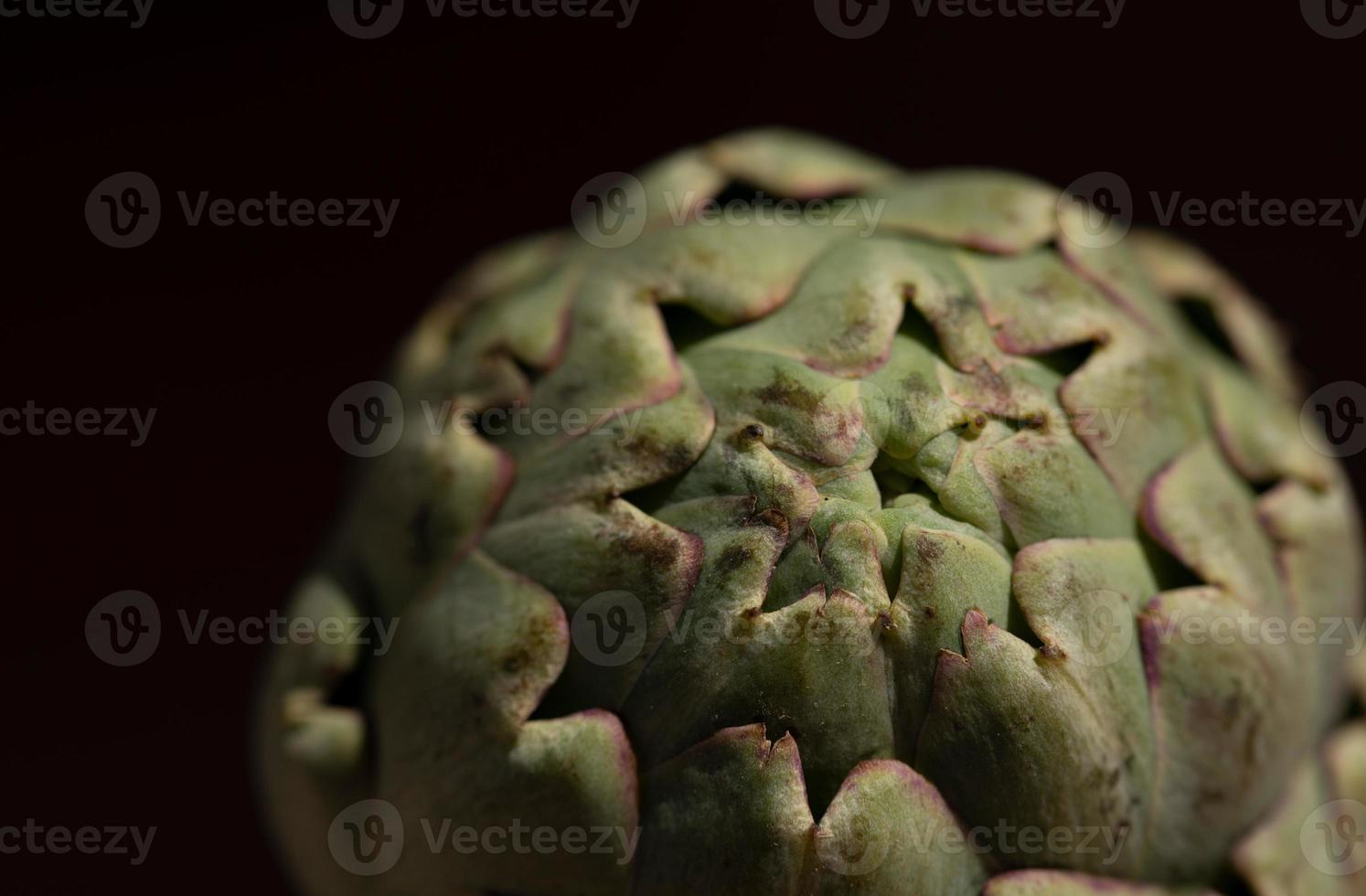 Close-up of an artichoke, against a dark background photo