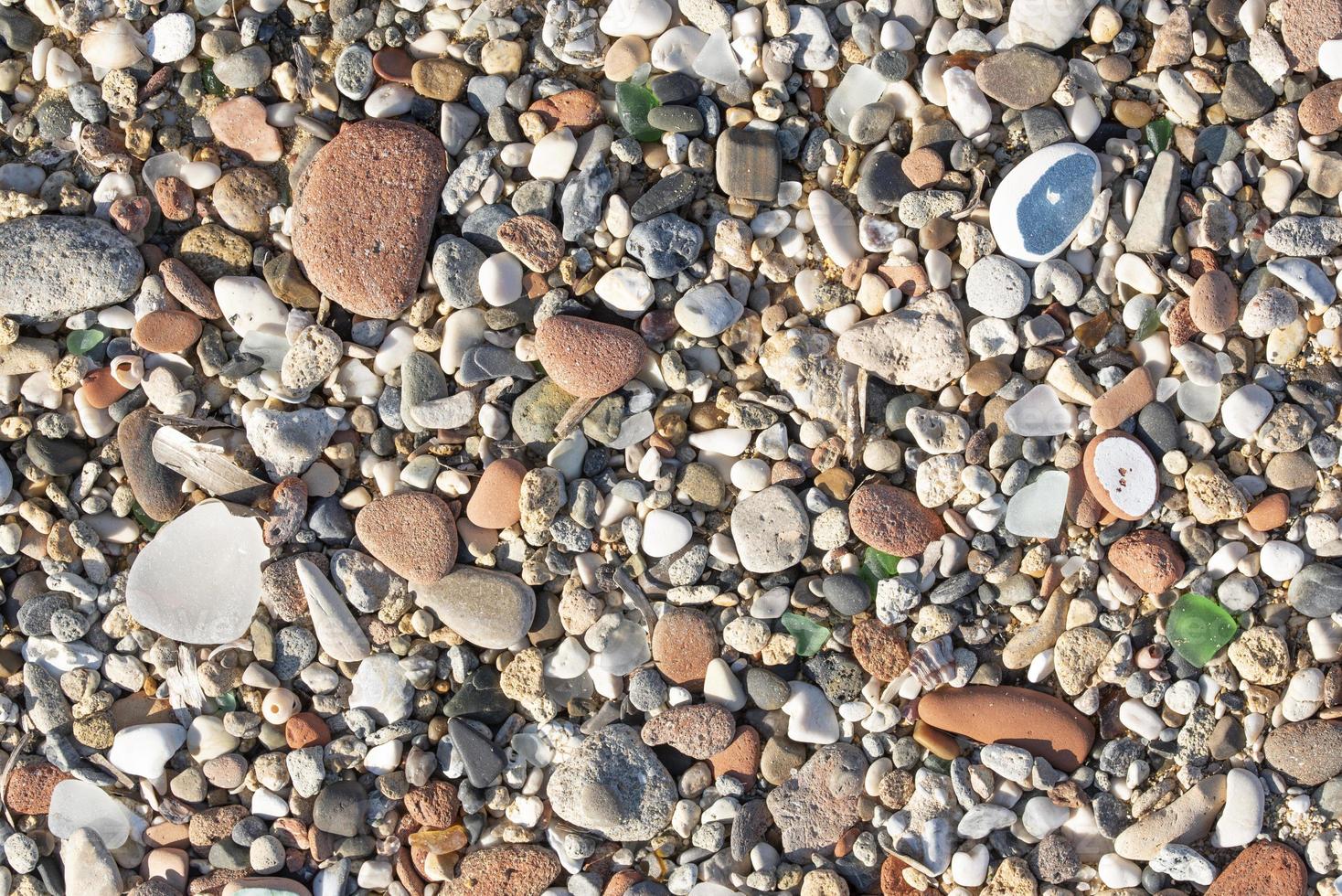 Background and texture of many round stones, cut by the sea and lying on top of each other, with cut shards in between photo