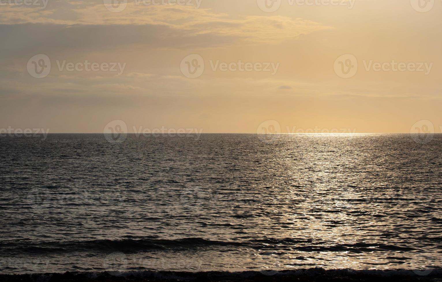 Background and scenic image with horizon of the sun setting on the sea photo