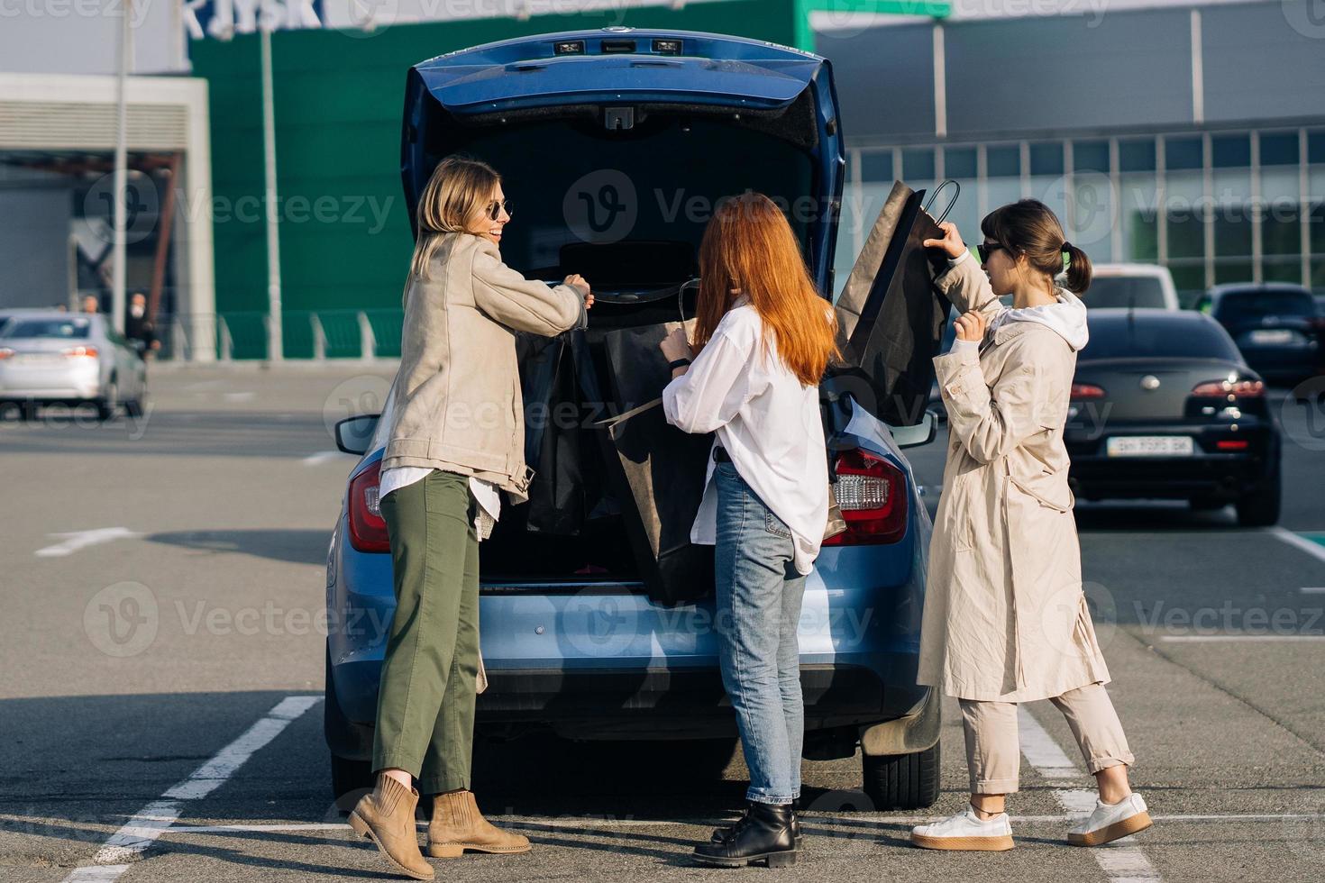 mujeres jóvenes en el auto con bolsas de compras foto