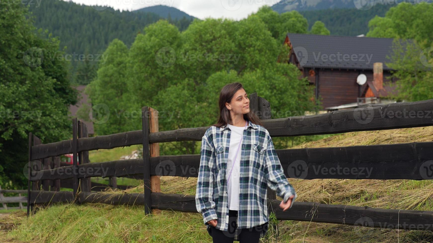 A young attractive Caucasian female stand by a fence photo