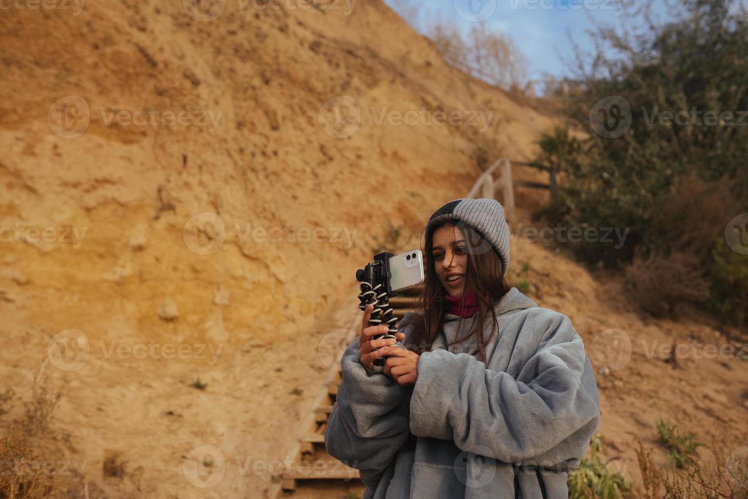 Young woman takes a photo on a smartphone of the seascape