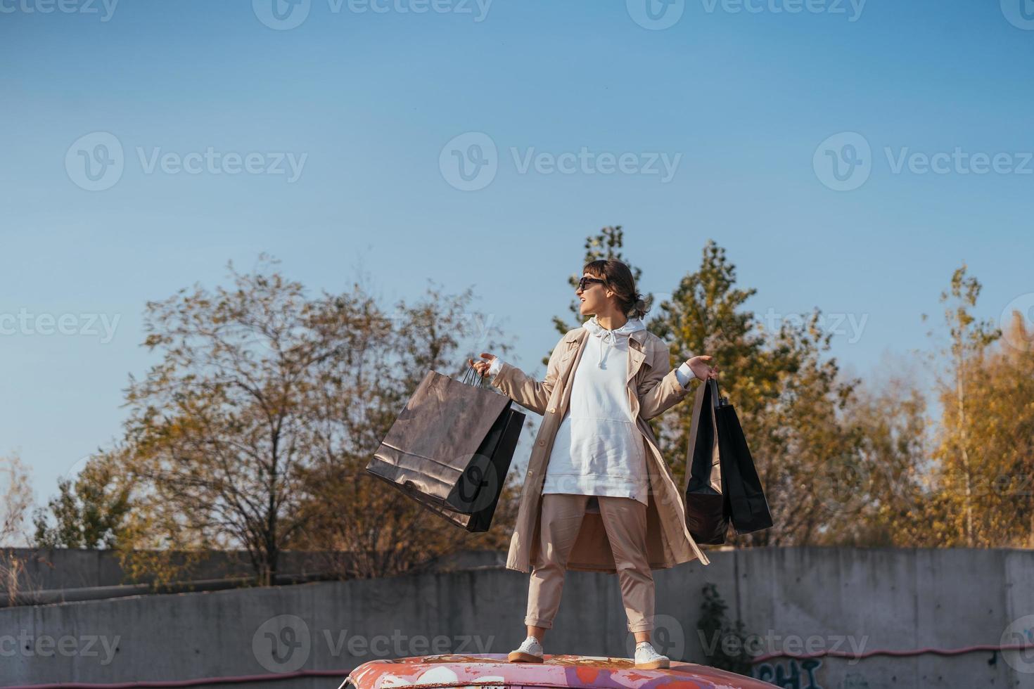 A young woman is standing in a car with bags in her hands photo