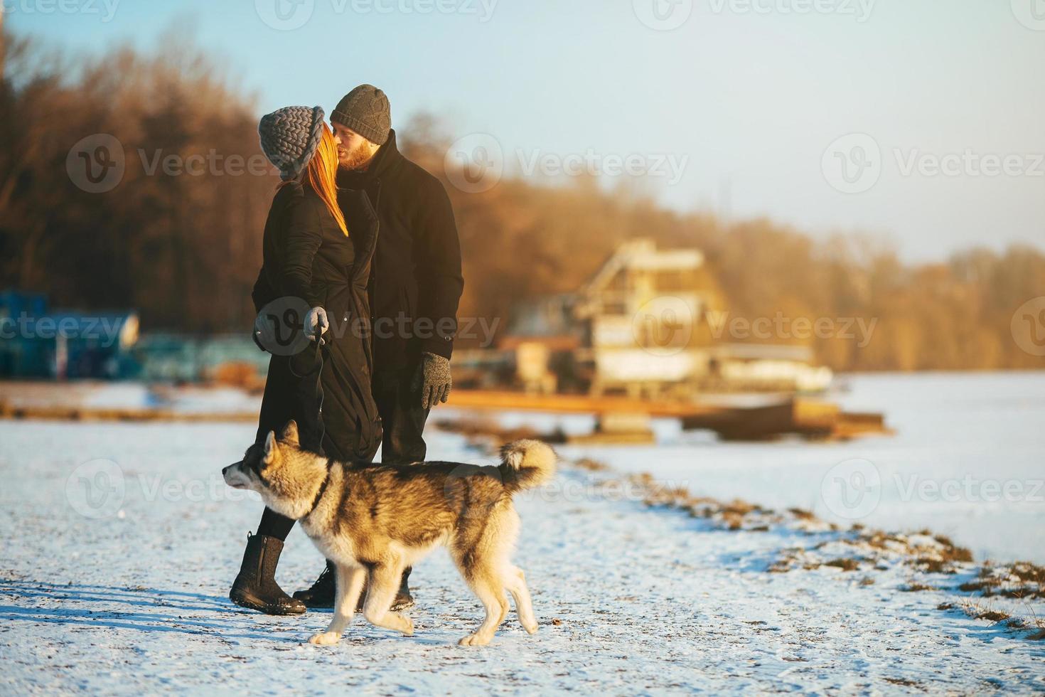 Couple with dog on the snow photo
