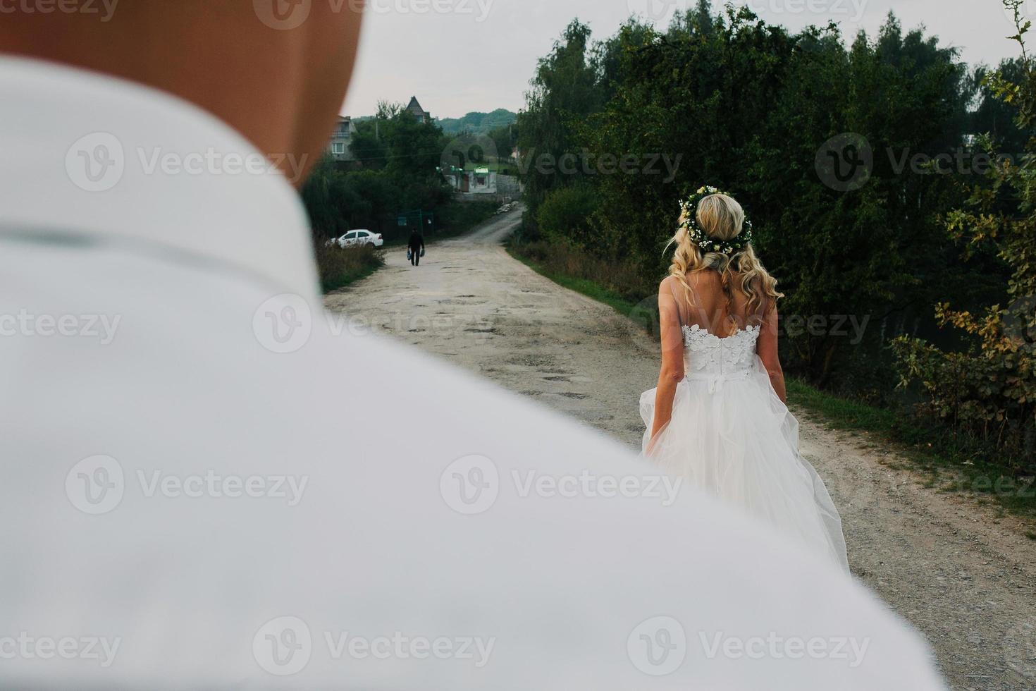 bride leads groom on the road photo