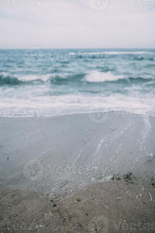 mar con las olas rompiendo en la playa creando rocío de mar. foto