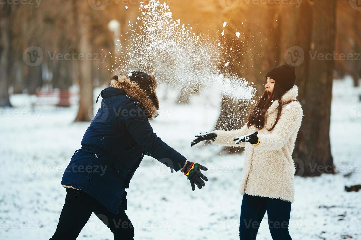 boy and girl playing with snow photo