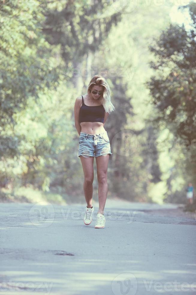 beautiful girl walking down a forest road photo