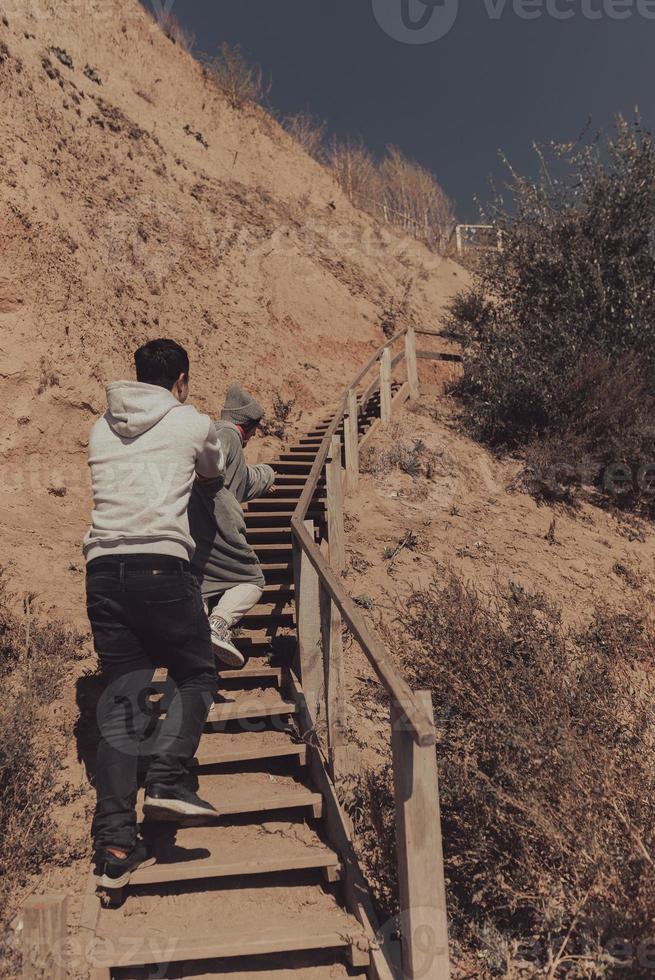 hombre y mujer suben las escaleras juntos junto al mar foto