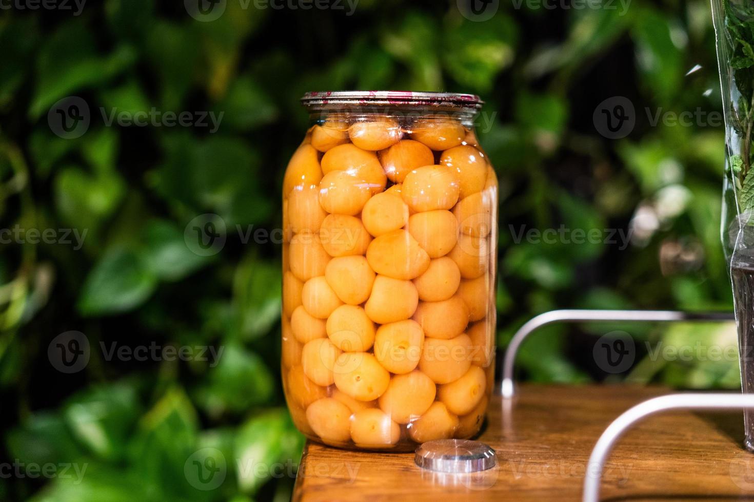 Jar of cherry plum compote close view photo