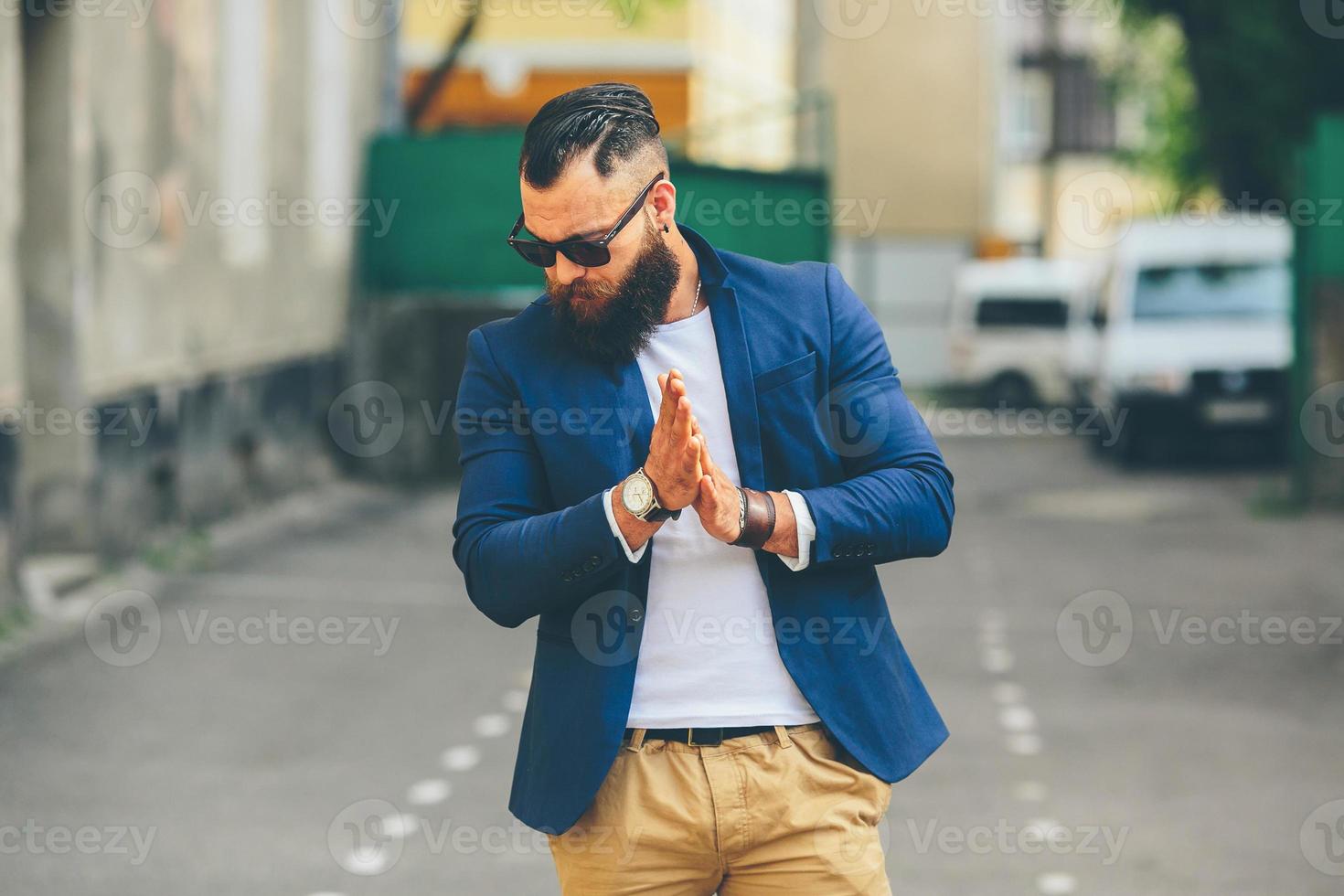 elegante hombre barbudo camina por la ciudad foto