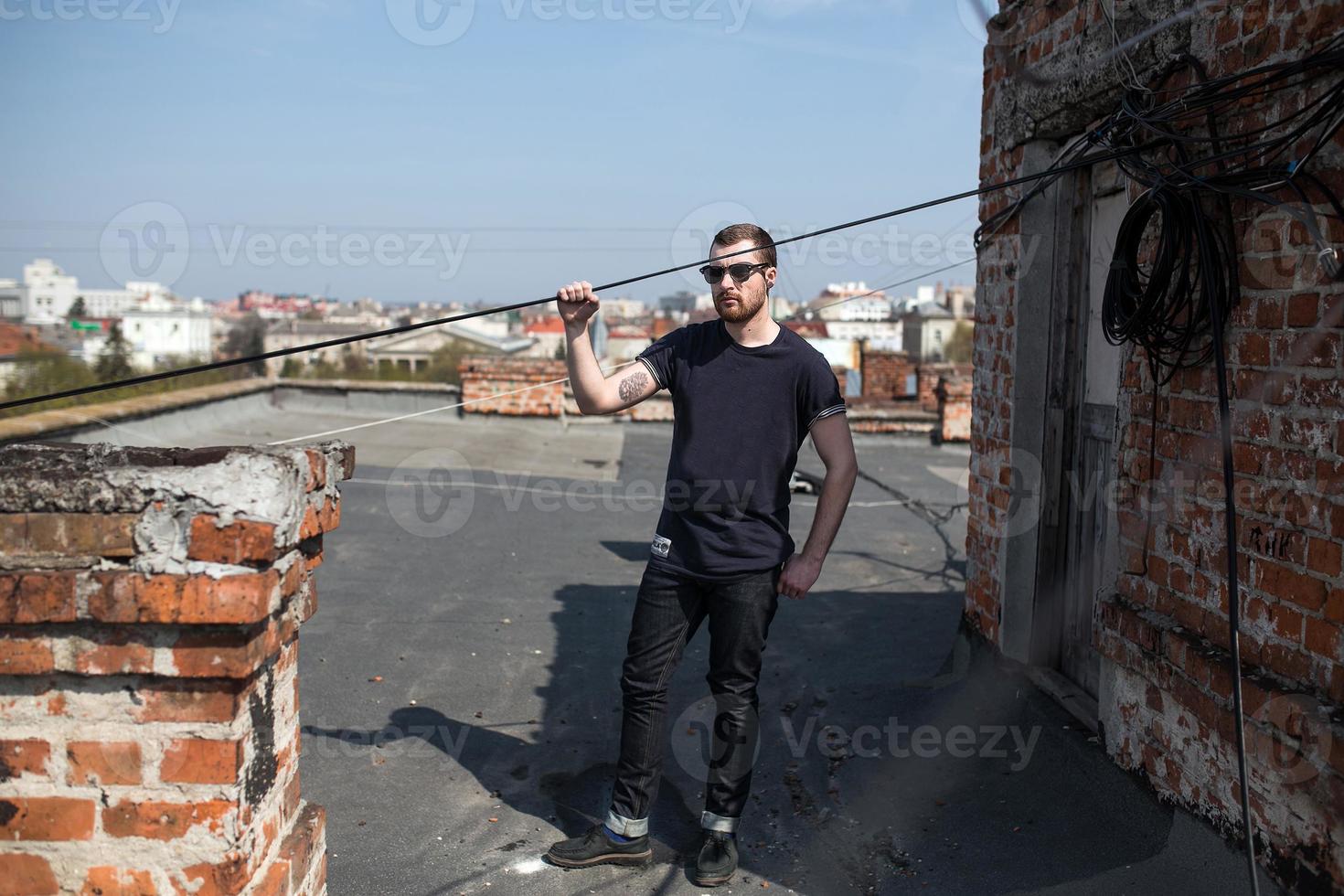 The man in the authentic boots and jeans selvedge on the roof of the building in the old town photo