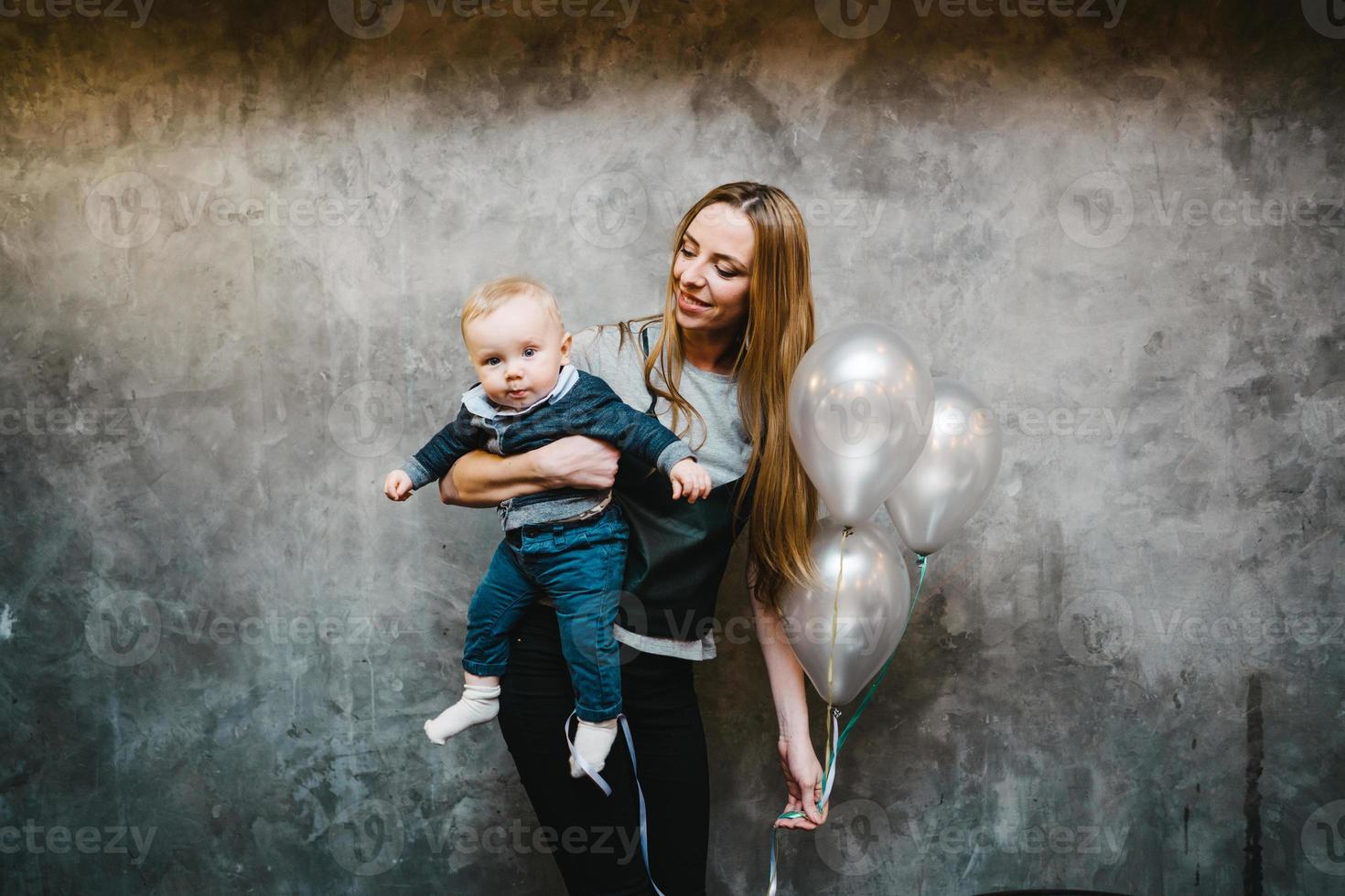 mamá está sosteniendo a su pequeño hijo en sus brazos foto