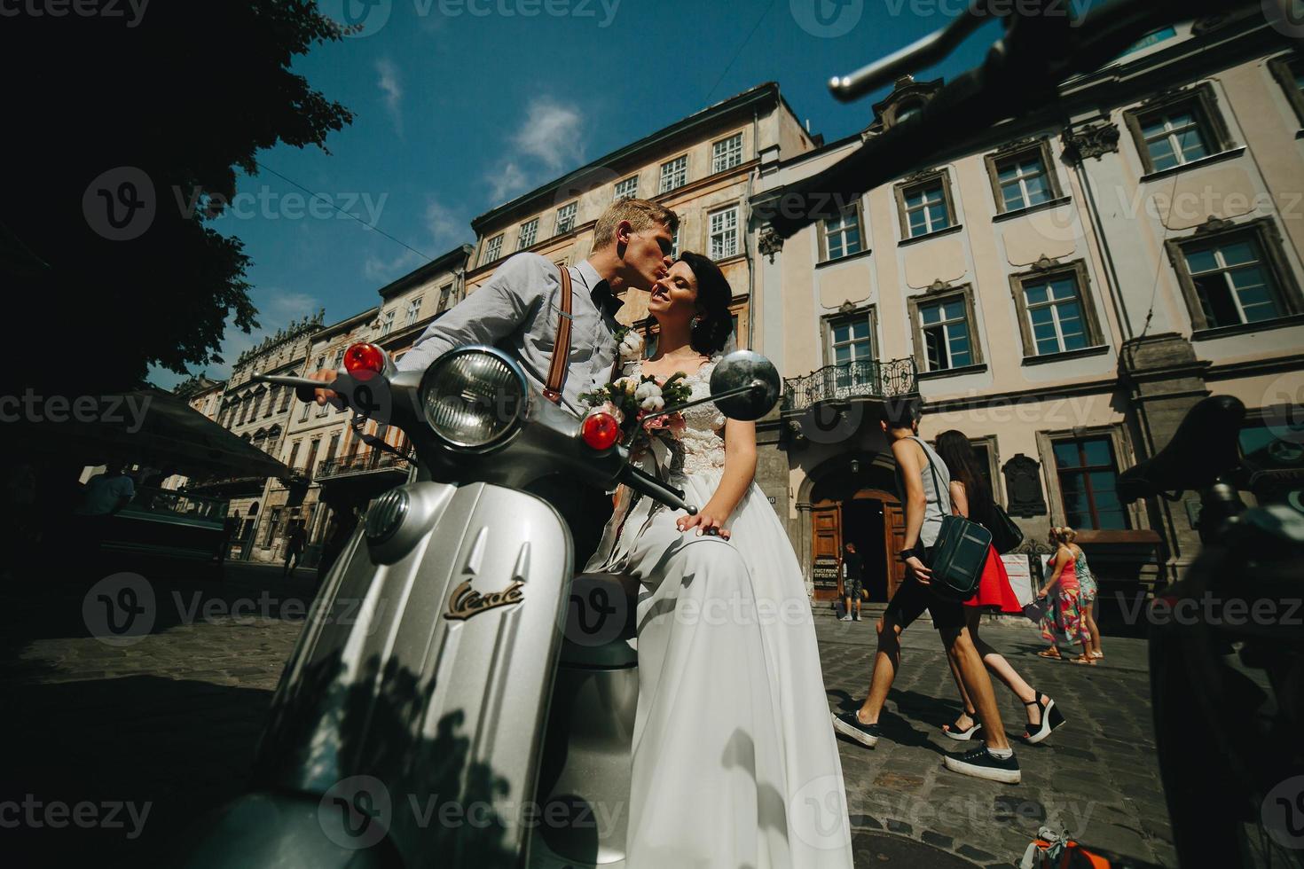 bride and groom on vintage motor scooter photo